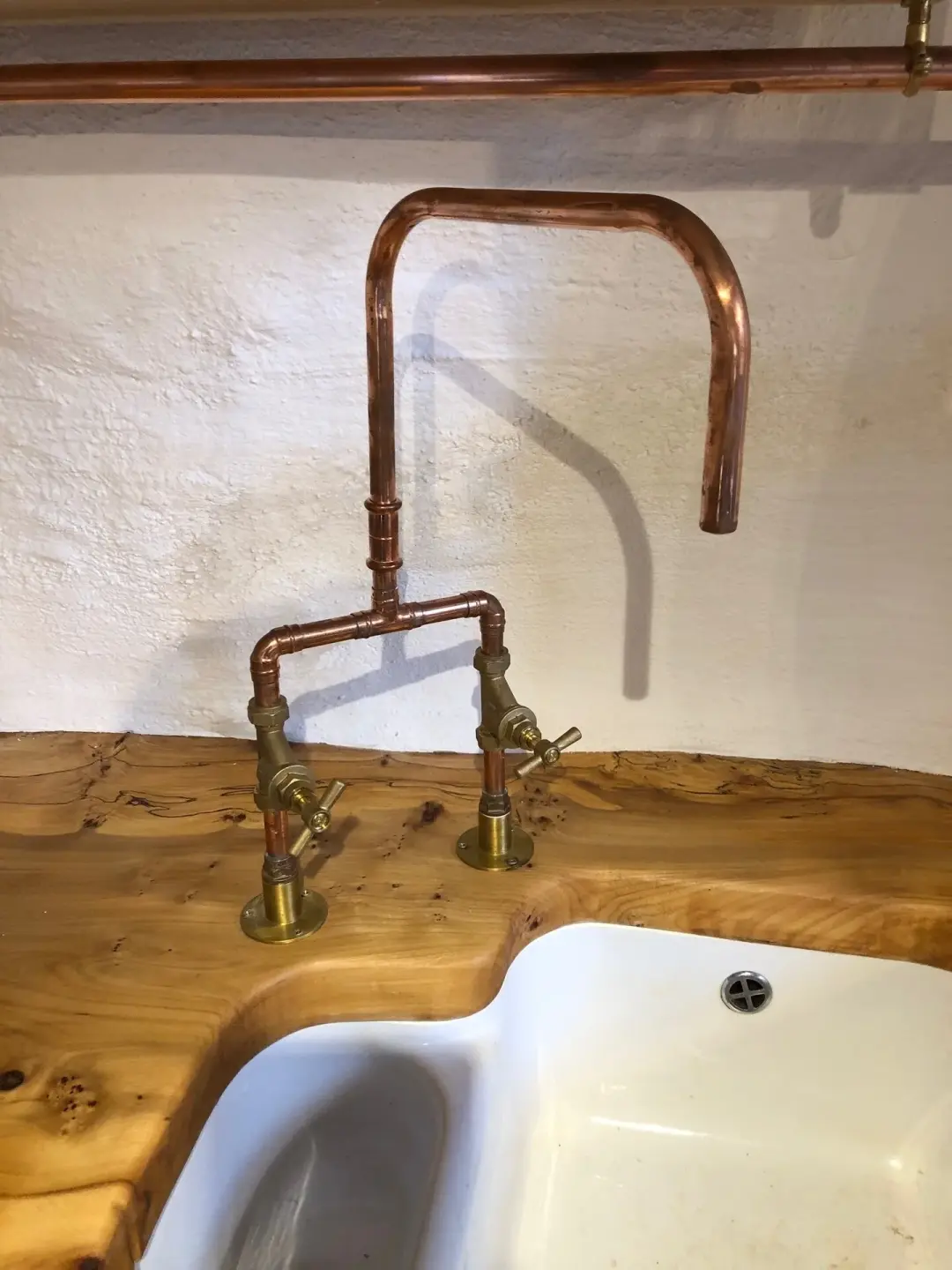 Copper tap over a white sink set in a wooden worktop